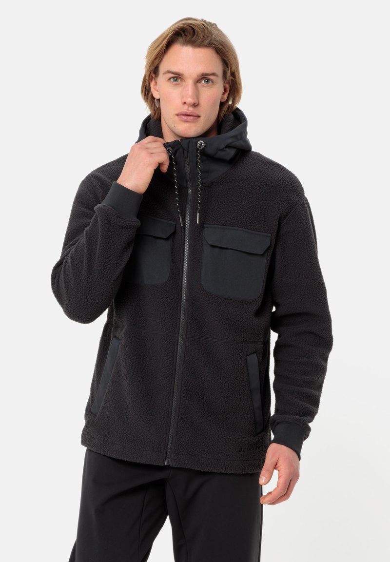 Jacket in pile nero con chiusura a zip, due tasche sul petto e tasche laterali. Presenta un cappuccio e un tessuto testurizzato con lembi di protezione lisci.