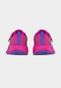 Ζευγάρι ζωντανών ροζ και μοβ αθλητικών παπουτσιών, που βλέπονται από πίσω, με τη φράση «Noosa Tri 16» σε κάθε τακούνι.