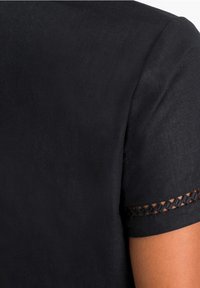 Schwarzes kurzärmeliges Hemd aus glattem Stoff, mit einer dekorativen gemusterten Akzentuierung am Ärmelrand.