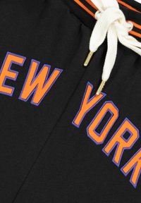 Černé bavlněné šortky s nápisem "NEW YORK" v tučném oranžovém a fialovém písmu. Bílé šňůrky s zlatými koncovkami a pruhovaný pas.