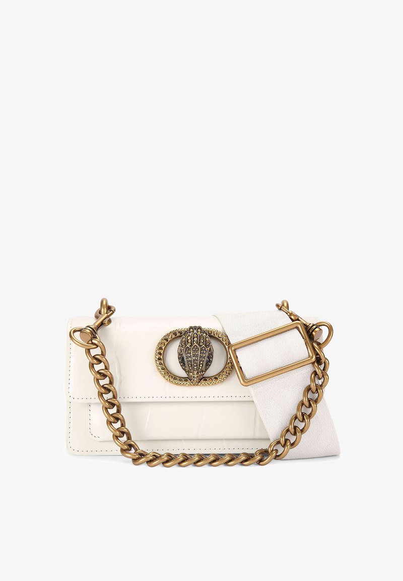 Biała torebka z lakierowanej skóry z złotym łańcuszkiem, ozdobiona dekoracyjnym zapięciem i kontrastowym akcentem z tkaniny.