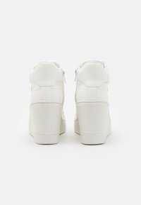 Vita högskor med kilklack, med slät läderstruktur, sidofickor med dragkedja och sydda detaljer på baksidan.