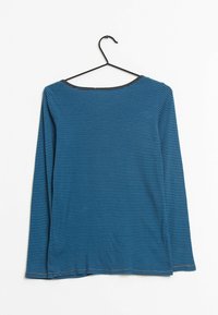 Camicia a maniche lunghe a righe blu e nere con colletto rotondo e bordino nero al colletto, esposta su una gruccia nera su uno sfondo bianco.