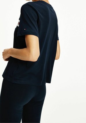 Granatowy bawełniany t-shirt z krótkimi rękawami, okrągłym dekoltem oraz subtelnym logo na rękawie. Gładka faktura i luźny krój.