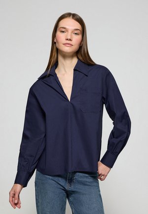 Camicia a maniche lunghe blu navy con colletto, taschino singolo sul petto e vestibilità leggermente rilassata, realizzata in tessuto morbido.
