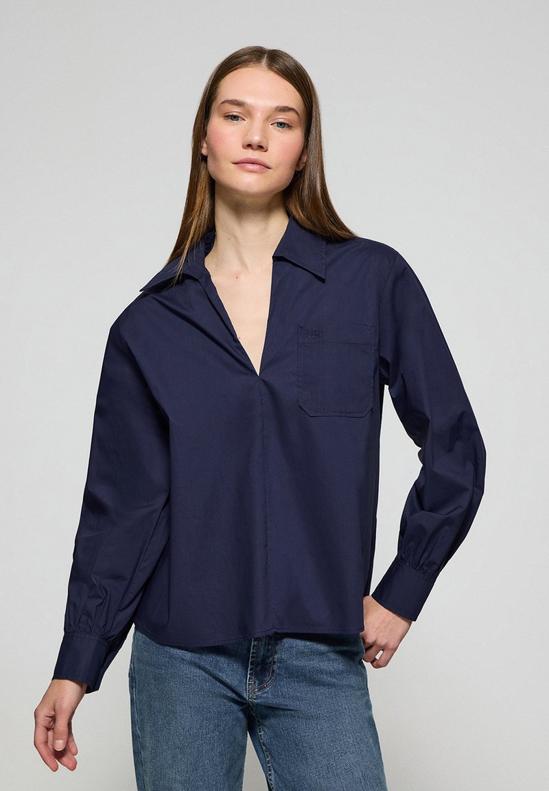 Camicia a maniche lunghe blu navy con colletto, taschino singolo sul petto e vestibilità leggermente rilassata, realizzata in tessuto morbido.