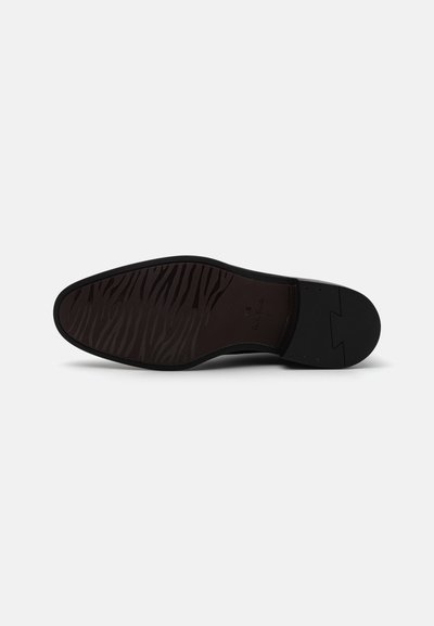 Schwarze Schuhsohle mit einem glatten Design, das ein strukturiertes, zebraartiges Muster und einen leichten Absatz aufweist.
