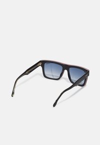 Occhiali da sole neri con montatura rettangolare, lenti blu sfumate, dettagli dorati e decorazioni rosse lungo la montatura.