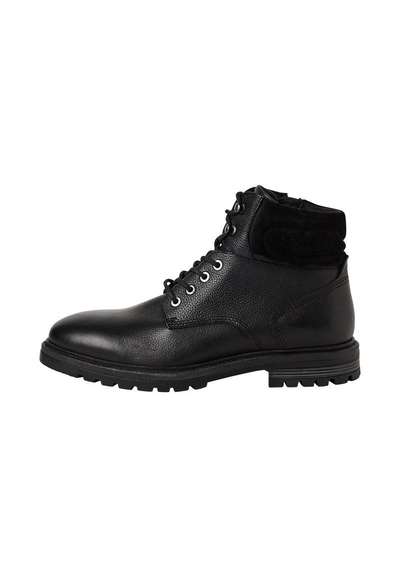 Bottine en cuir noir avec col rembourré, lacets à l'avant, œillets en métal et semelle en caoutchouc robuste, présentée en profil latéral sur fond blanc.