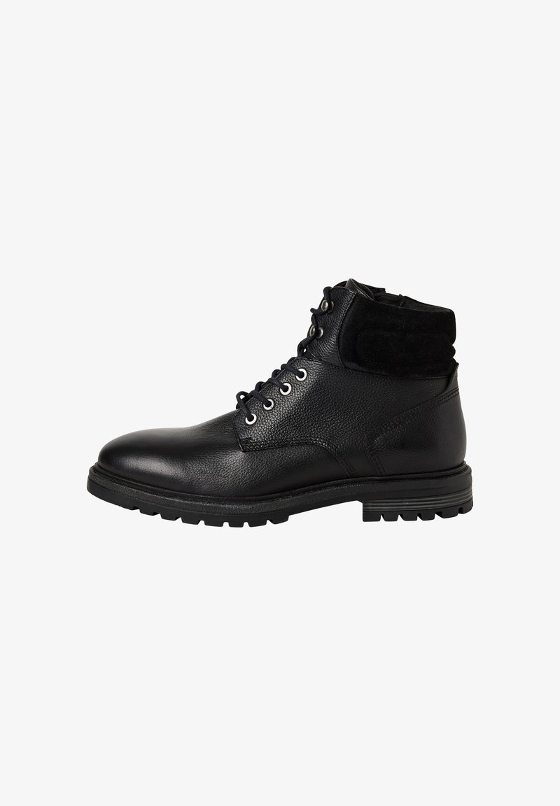 Bottine en cuir noir avec col rembourré, lacets à l'avant, œillets en métal et semelle en caoutchouc robuste, présentée en profil latéral sur fond blanc.