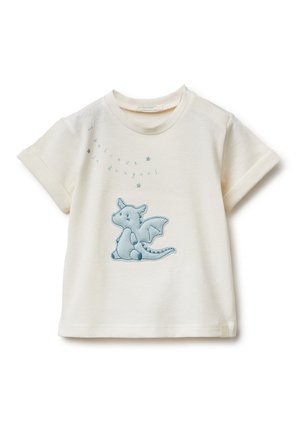 Maglietta per bambino di colore crema con maniche arrotolate, con un drago blu ricamato e la frase "Credo nei draghi" con piccole stelle sopra.