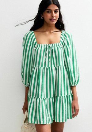 Groen en wit gestreepte jurk met een vierkante halslijn, pofmouwen en een gelaagd ontwerp. Bevat een trekkoorddetail bij de halslijn.
