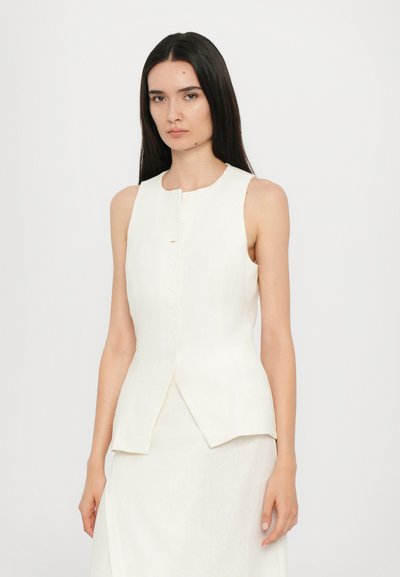 Sleeveless cream vest top in a textured fabric, featuring a round neckline and six button closure, with a slightly flared hem.