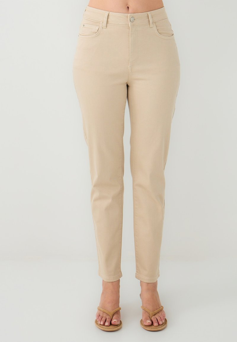 Pantalons slim beige avec une texture lisse, poches avant et fermeture à bouton. Design de jambe fuselée, atteignant le mollet.
