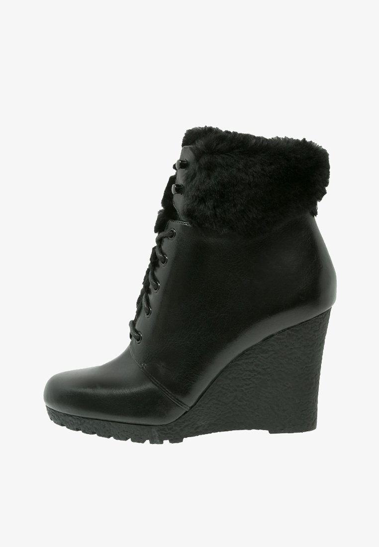 Bottines compensées en cuir noir avec un revers en fausse fourrure, un bout rond, un laçage à l'avant et une semelle compensée texturée.