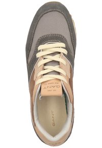 Sneaker gris et beige avec une tige texturée, dotée de lacets crème et d'une semelle intérieure à logo. Matériaux en daim et en tissu dans un design classique.