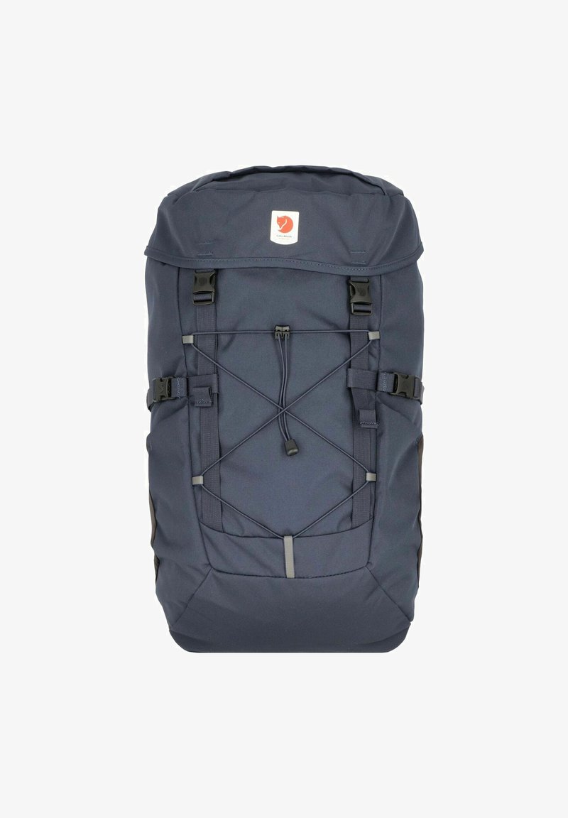 Dunkelblauer Rucksack mit Rolltop-Verschluss, vorderem Bungee-Seil, doppelt verstellbaren Trägern und einem gebrandeten Logo-Patch auf der Vorderseite.