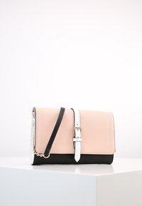 Różowa i czarna torebka z faux skóry z odpinanym białym paskiem, zapięcie na klapkę oraz złotymi akcentami. Gładka tekstura z usztywnionym kształtem.