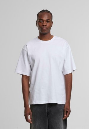 Witte katoenen t-shirt met een ronde hals en korte mouwen, met een relaxte pasvorm en een gladde textuur. Draag met donkergrijze broek.