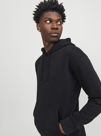 Black hoodie made of soft fabric with a front pocket, drawstring hood, and ribbed cuffs, featuring a simple, classic design.