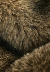 Soft, dense faux fur in shades of brown with black accents, featuring a varied texture of long and short strands, creating visual depth.