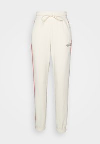 Krämmiga sweatpants med elastisk midja, dragsko och röda sidostrecker. Har en broderad logotyp på låret. Mjuk bomullsmaterial.