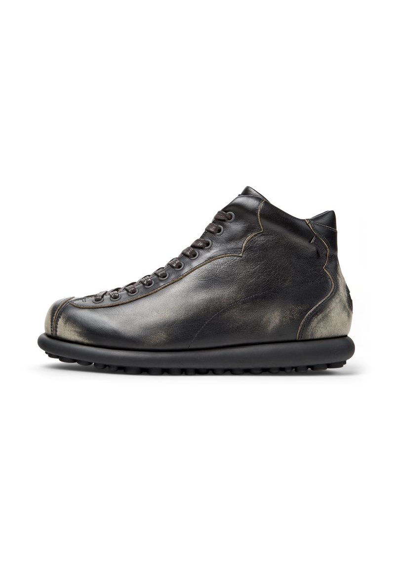 High-top leather shoe in black with a textured finish, featuring laces, rounded toe, and a thick rubber sole with traction.