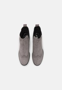 Botas de tobillo de ante gris con borde en forma de ondas y detalles de brogue, con un forro de ante negro y un lazo para facilitar su uso. Talla 37.