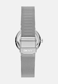 Silberne DKNY-Uhr mit Mesh-Armband, rundem Ziffernblatt, metallischem Verschluss und minimalistischer Gestaltung mit glatter Oberfläche.