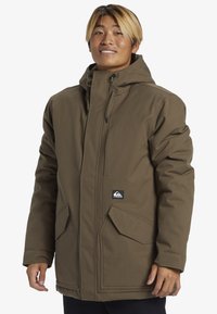 Brun isolerad parka med huva, med stora framfickor, dragkedjestängning och dragsnören. Slät textur och minimalistisk design.
