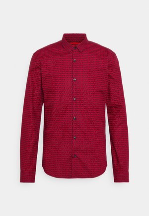 Red long-sleeve button-up shirt with repeating black "HUGO" text pattern all over, displayed against a plain light background.