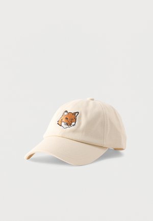 Bēša beisbola cepure ar izliekto malu, priekšpusē centrā izšūts oranžas lapsas galva.