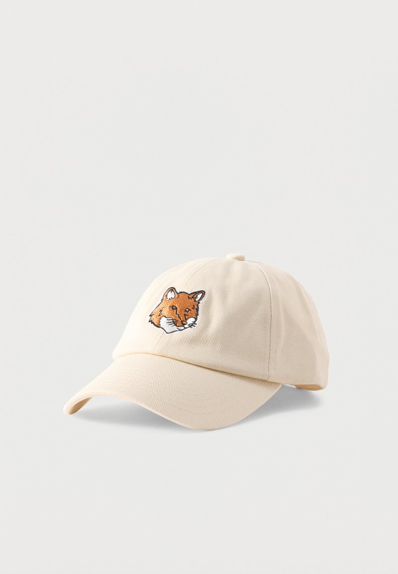 Μπεζ καπέλο μπέιζμπολ με κυρτή γείσο που φέρει κεντημένο πορτοκαλί κεφάλι αλεπούς στο μέσο μπροστά.