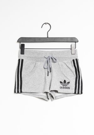 Short gris Adidas avec des bandes noires sur les côtés et une taille à cordon, suspendu sur un cintre noir sur fond blanc.