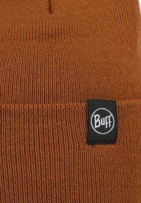 Gorra de punto marrón con textura acanalada, que cuenta con una etiqueta de tela negra con el logo "Buff" cosido en el borde.