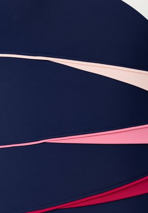 Gebogen stoffen panelen in laagjes in marineblauw, lichtroze, roze en rood met zichtbare stiksels langs de randen.