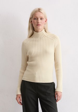 Cremfarbener, gerippter Rollkragenpullover mit langen Ärmeln und figurbetonter Passform, der eine glatte Textur und einen leicht verkürzten Saum aufweist.