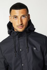 Waterproof black jacket with a hood, featuring a smooth texture, adjustable drawstrings, and a small logo on the chest.
