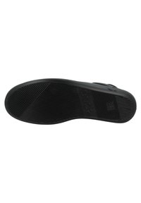 Suola di scarpa nera con superficie in gomma texture, caratterizzata da scanalature orizzontali e verticali per una buona aderenza, e dettagli del logo in rilievo.
