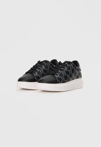 Black and gray sneakers with a houndstooth pattern, featuring a smooth leather upper and a white rubber sole. Black laces and minimal branding.
