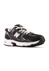 Bottines de sport noires en matériau en maille, avec des lacets blancs et des accents argentés. Présente une semelle rembourrée et une semelle extérieure en caoutchouc noir texturé.