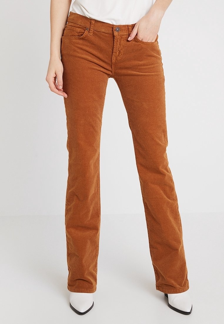 Bruine corduroy broek met een recht model, voorzien van een knoop- en ritssluiting aan de voorkant, vijf zakken en een subtiele stoftextuur.