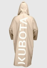 Beżowy płaszcz przeciwdeszczowy z kapturem, z dużym białym nadrukiem "KUBOTA" z tyłu. Wykonany z lekkiego, wodoodpornego materiału.