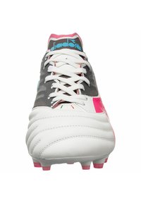 Scarpe da calcio bianche con tomaia testurizzata, accenti rosa e un design grigio a motivi. Presentano lacci bianchi e una fodera interna rosa.