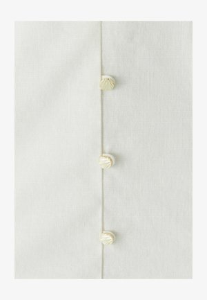 Bílá lněná tkanina s třemi ozdobnými knoflíky s texturovaným vzorem mušle podél jedné strany, zdůrazňující jemné detaily řemeslné práce.