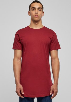 Rød bomulds T-shirt med korte ærmer og rund hals. Har en lige pasform og en glat tekstur. Bæres med blå jeans.