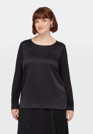 Zwarte lange mouw top met een ronde halslijn, met een gladde, glanzende textuur en een losse pasvorm, gecombineerd met een geplooide zwarte rok.