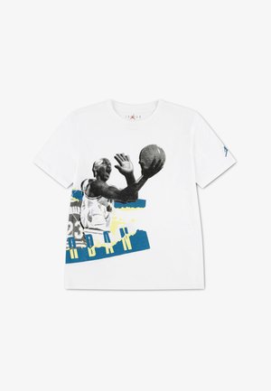 T-shirt en coton blanc avec un imprimé graphique d'un joueur de basket-ball, avec des accents noirs, bleus et jaunes et un col rond.