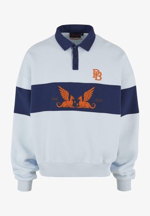 Langärmliges Polo-Sweatshirt in Hellblau und Marineblau, mit orangefarbenem gesticktem Logo und einem geflügelten Greif-Design auf der Brust.