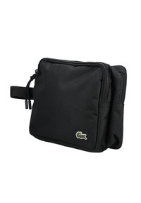 Bolsa de tela negra con dos compartimentos con cremallera, que presenta un acabado texturizado y un pequeño logo bordado de Lacoste en color en la parte frontal.